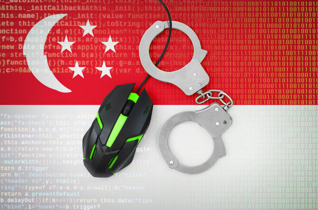 Singapore flag and handcuffed modern backlit computer mouse
