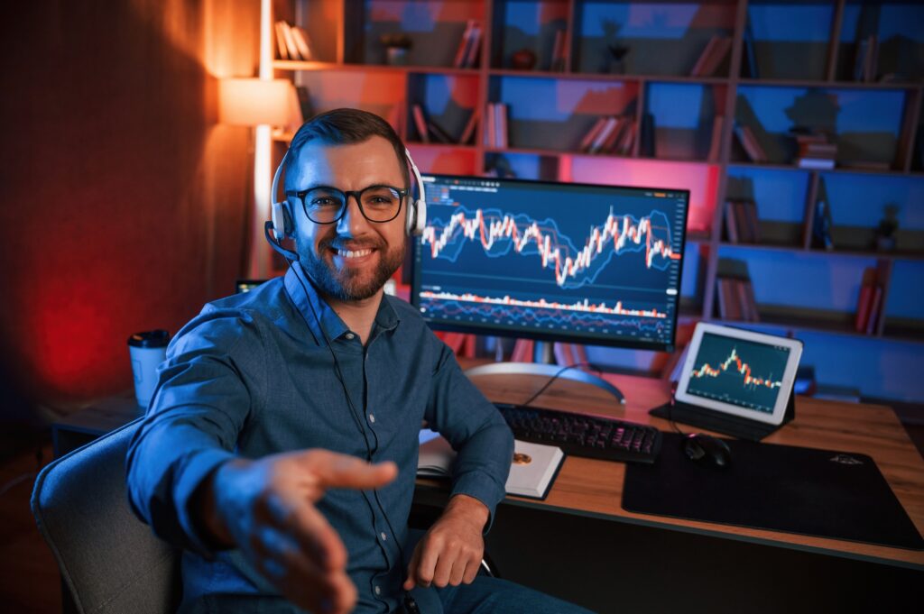 Stock trader is working by pc indoors. Conception of exchange and money